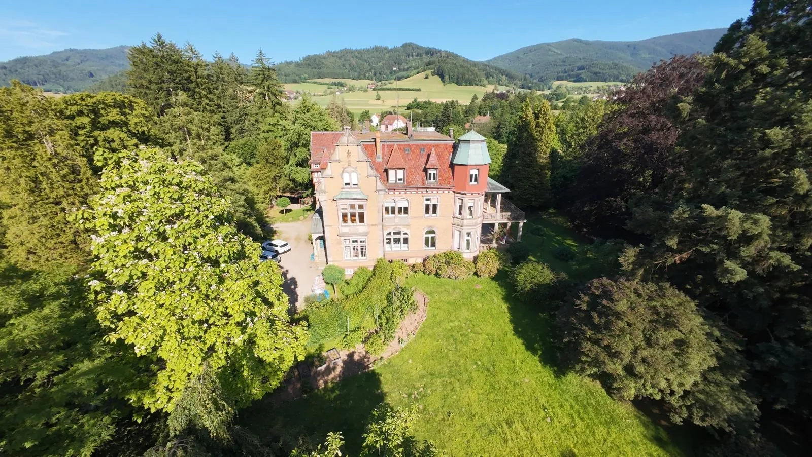 Luftaufnahme der Villa Oretha in Gutach mit Garten und bewaldeten Hügeln im Hintergrund